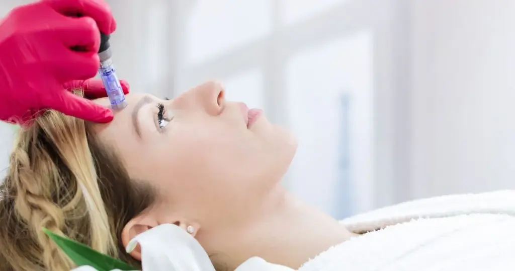 A woman receiving microneedling treatment on her forehead in Reno, NV